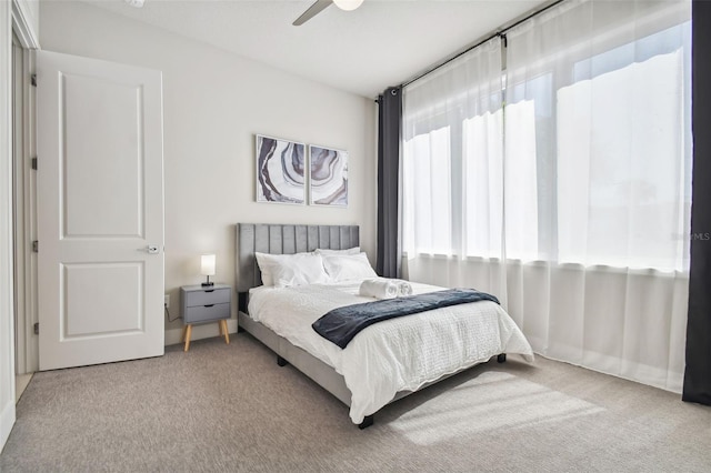 carpeted bedroom with multiple windows and ceiling fan