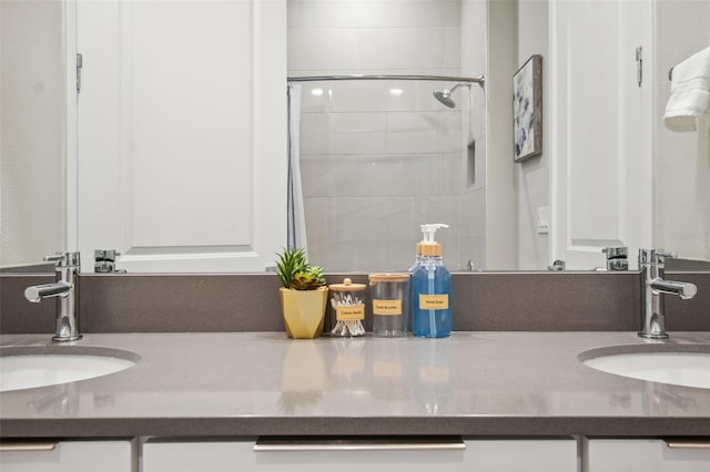 bathroom featuring tiled shower and vanity