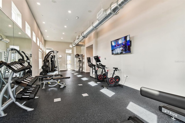 exercise room featuring a towering ceiling