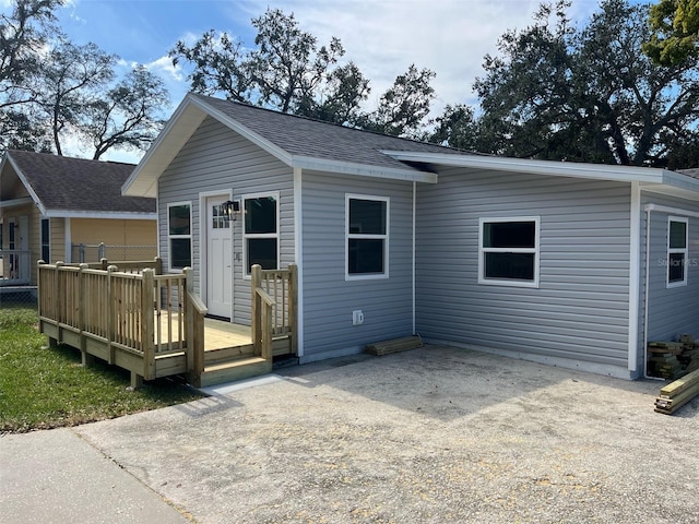 rear view of property featuring a wooden deck