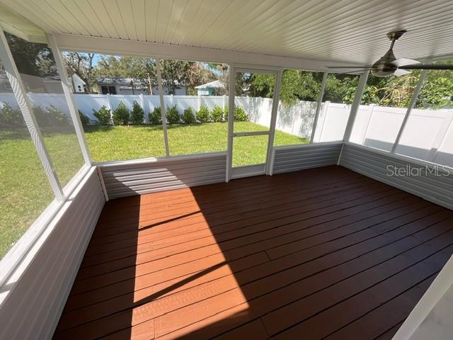 unfurnished sunroom with ceiling fan