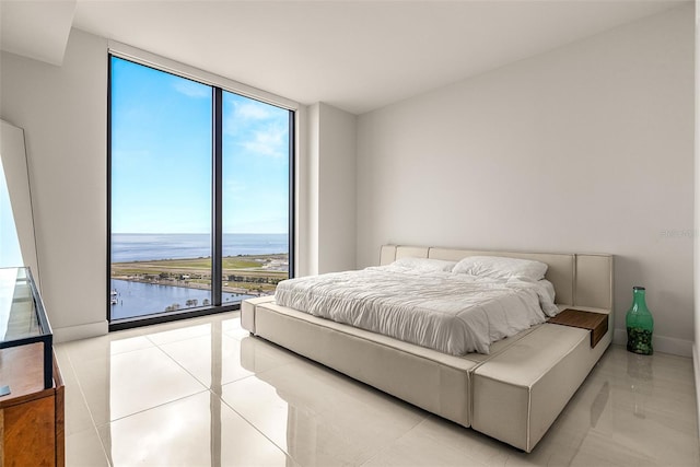 bedroom featuring a wall of windows and a water view