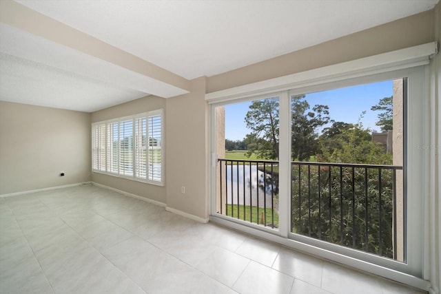 unfurnished room with plenty of natural light and light tile patterned floors