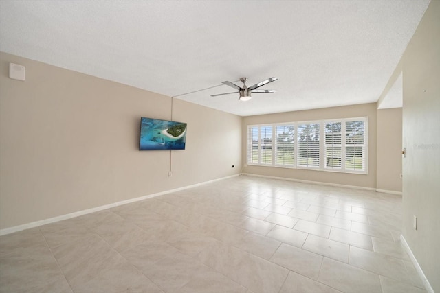 unfurnished room with a textured ceiling, ceiling fan, and light tile patterned flooring