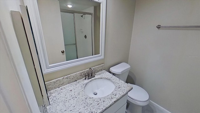 bathroom with vanity, toilet, and a shower with door