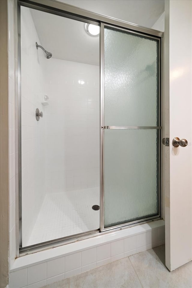 bathroom featuring tile patterned floors and a shower with door