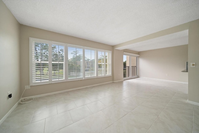 tiled spare room featuring a textured ceiling