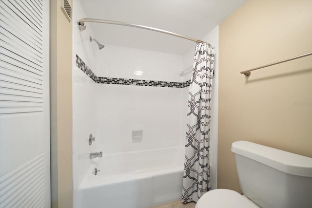 bathroom featuring shower / bath combo with shower curtain and toilet