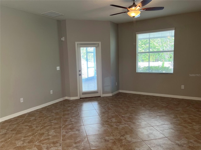 spare room featuring tile patterned flooring, ceiling fan, and plenty of natural light