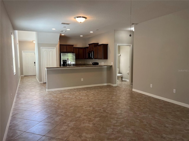 kitchen featuring dark brown cabinetry, appliances with stainless steel finishes, light tile patterned floors, and kitchen peninsula