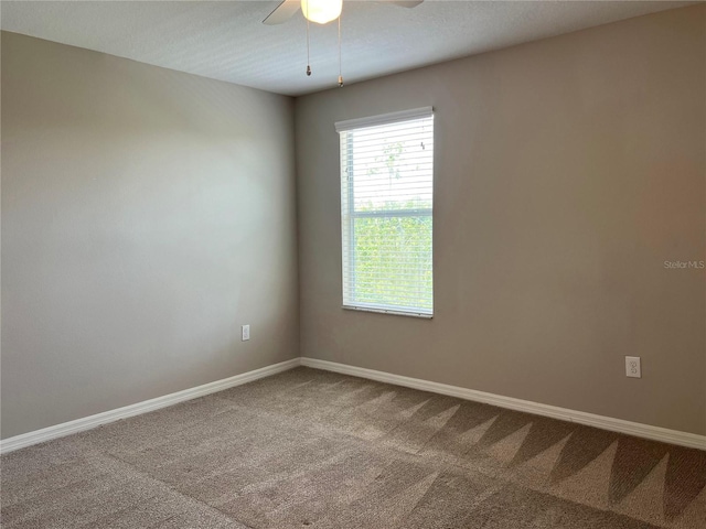 carpeted spare room featuring ceiling fan