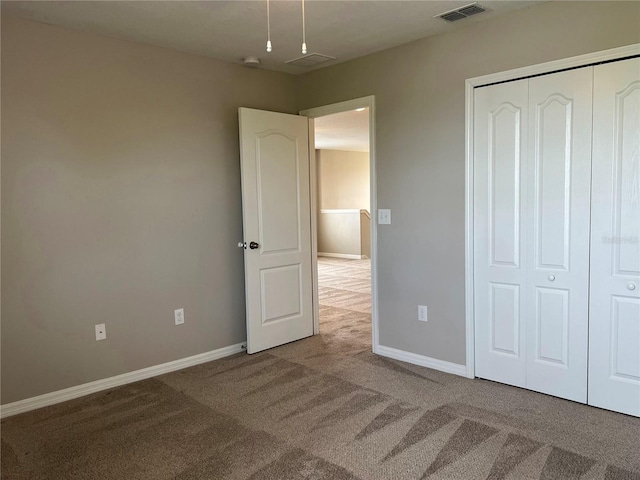 unfurnished bedroom with carpet floors and a closet