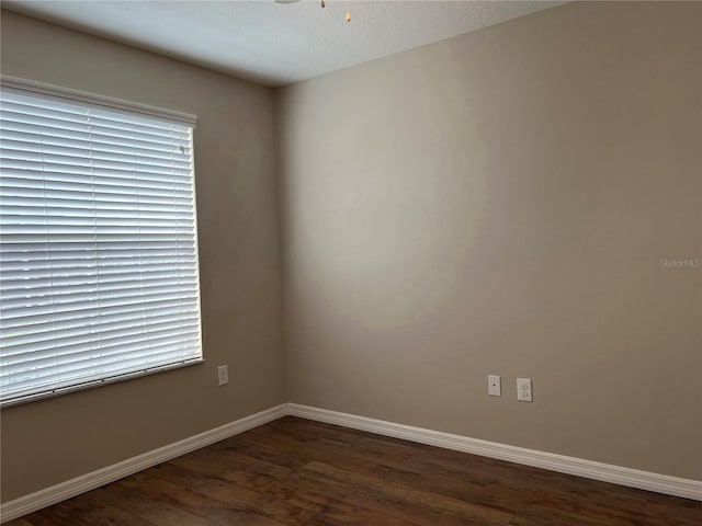 empty room with ceiling fan, a textured ceiling, and dark wood-type flooring