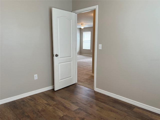 spare room with dark hardwood / wood-style floors and ceiling fan