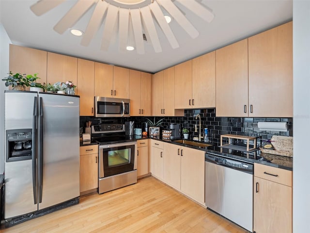 kitchen with light hardwood / wood-style floors, sink, decorative backsplash, stainless steel appliances, and light brown cabinetry