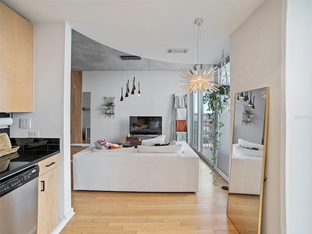 living room with light hardwood / wood-style flooring and an inviting chandelier