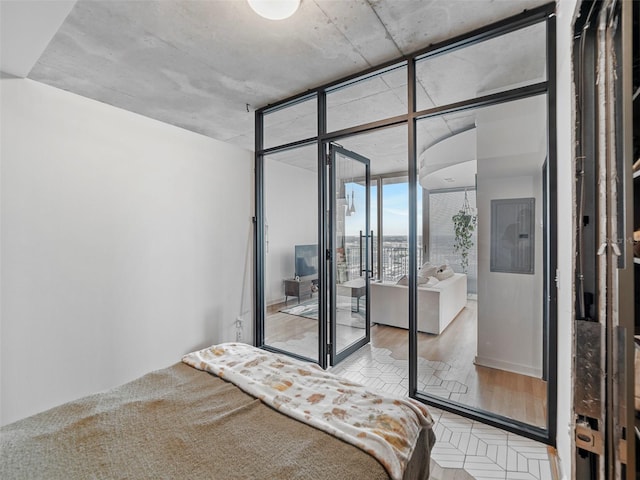 bedroom featuring light wood-type flooring and expansive windows