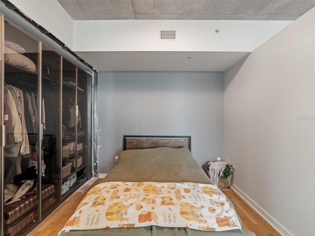 bedroom with a closet and hardwood / wood-style floors