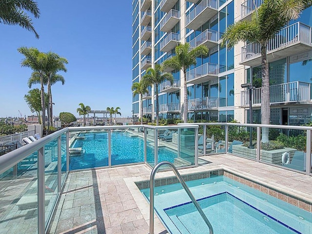 view of swimming pool with a hot tub