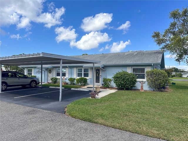 ranch-style home with a carport and a front lawn