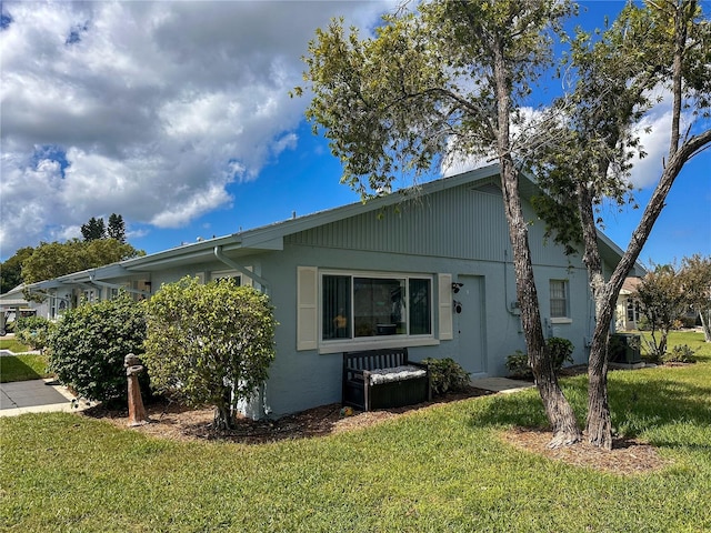 view of side of home with a lawn and central air condition unit