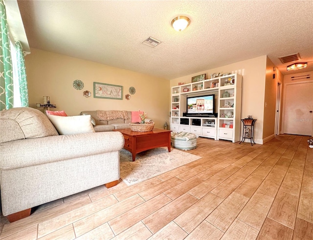 216 Gloucester Blvd Unit 216, Sun City Center, FL 33573 - living area featuring visible vents, a textured ceiling, and light wood-style floors