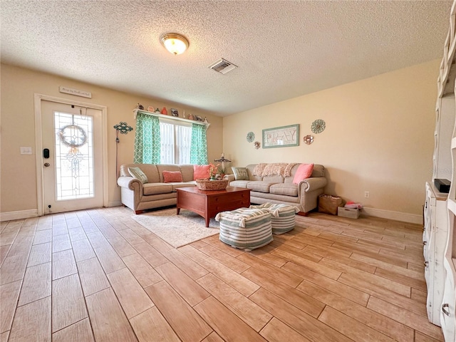 216 Gloucester Blvd Unit 216, Sun City Center, FL 33573 - living room featuring baseboards, a textured ceiling, visible vents, and light wood-style flooring