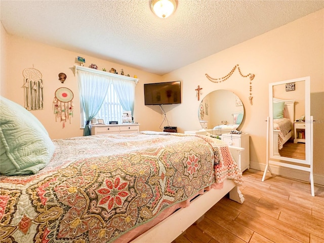 bedroom with a textured ceiling and hardwood / wood-style floors