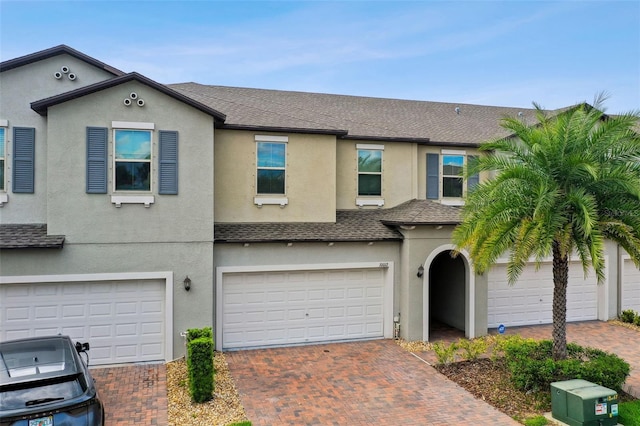 10012 Corso Milano Dr, Tampa, FL 33625 - view of front facade featuring decorative driveway, an attached garage, roof with shingles, and stucco siding
