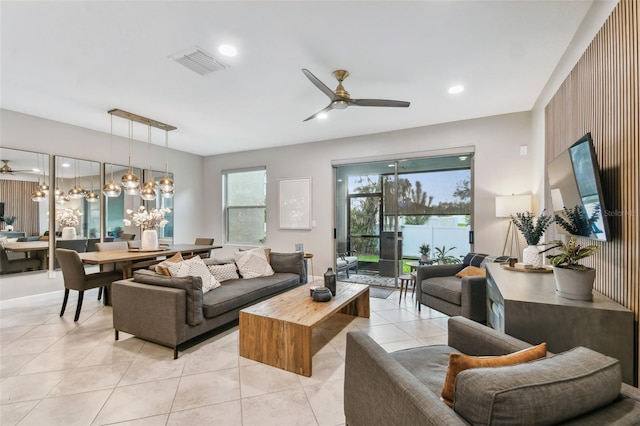 living room featuring ceiling fan with notable chandelier and light tile patterned flooring