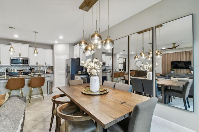 tiled dining room with ceiling fan and sink