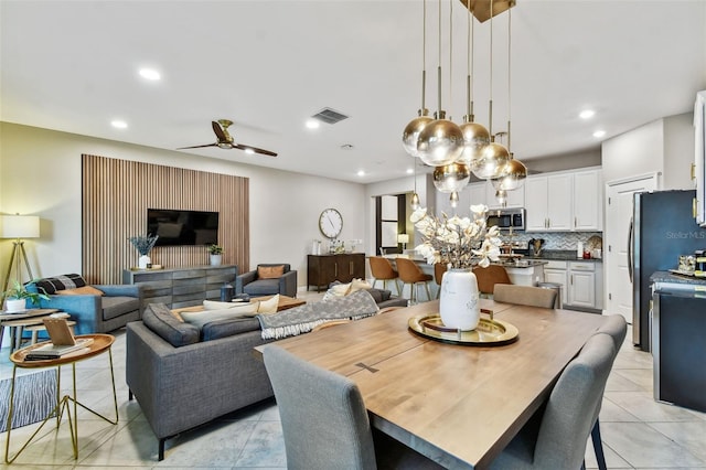 tiled dining space with ceiling fan