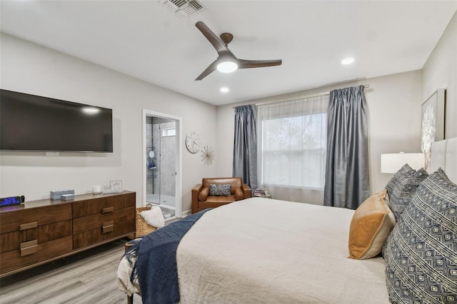 bedroom with light wood-type flooring, ceiling fan, and ensuite bathroom