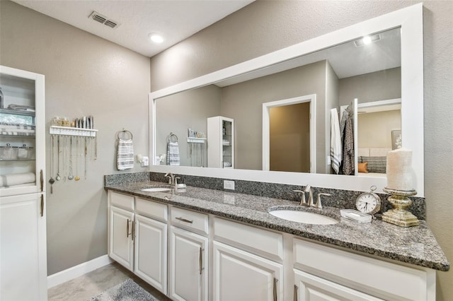 10012 Corso Milano Dr, Tampa, FL 33625 - full bath with visible vents, a sink, a textured wall, and double vanity