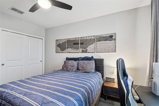 bedroom with hardwood / wood-style floors, ceiling fan, and a closet