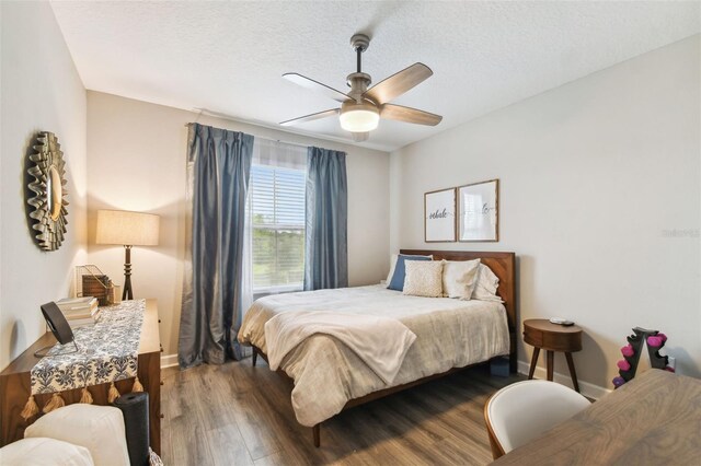 bedroom with a textured ceiling, dark hardwood / wood-style floors, and ceiling fan