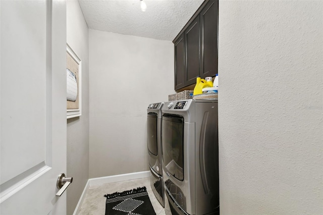 laundry area with a textured ceiling, independent washer and dryer, and cabinets