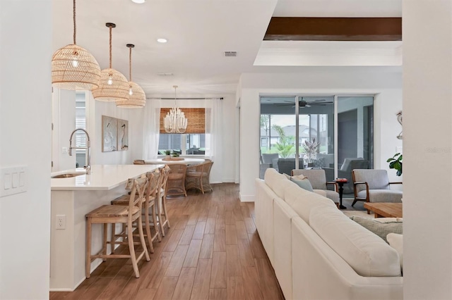 living room featuring sink, hardwood / wood-style floors, and ceiling fan