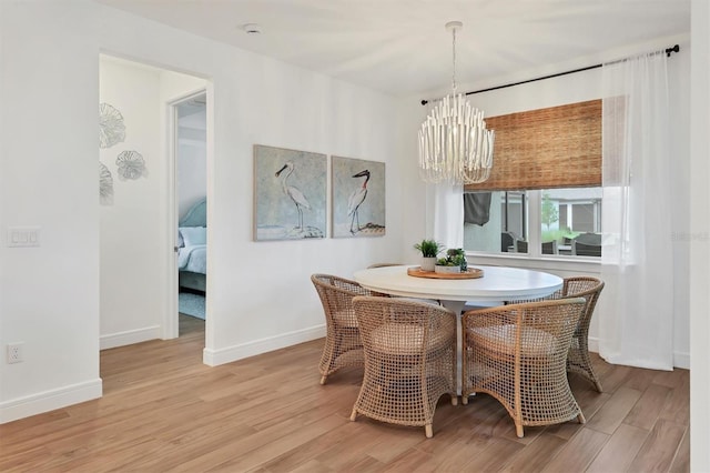 dining room with an inviting chandelier and light hardwood / wood-style flooring