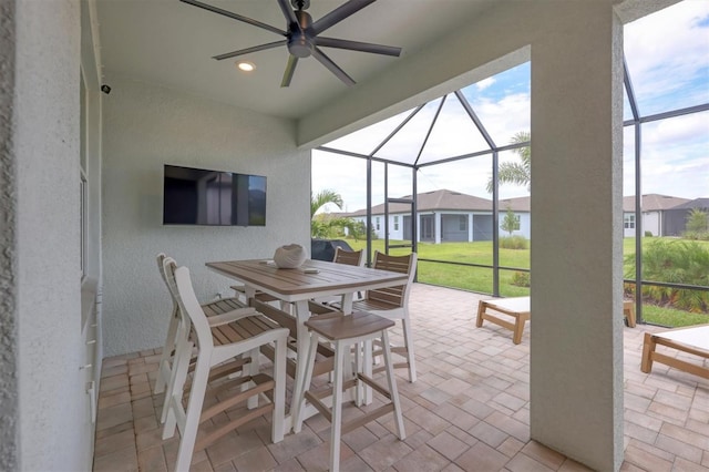 view of patio with glass enclosure and ceiling fan