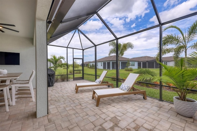 view of patio / terrace with glass enclosure, ceiling fan, and grilling area