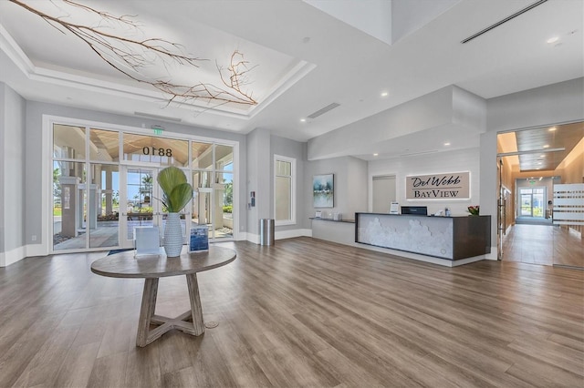 interior space featuring hardwood / wood-style flooring, a raised ceiling, and french doors