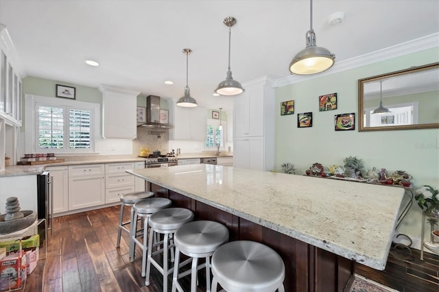 kitchen with ornamental molding, wall chimney range hood, dark wood finished floors, and white cabinetry