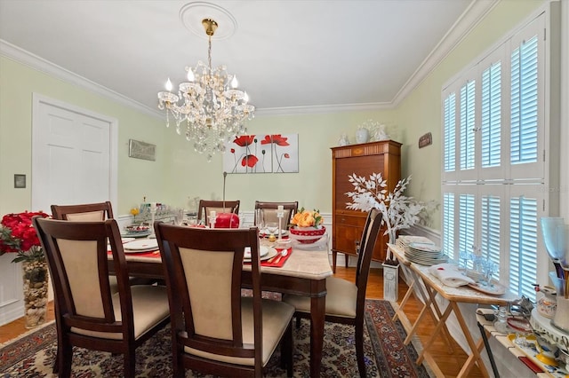 dining area featuring a chandelier, crown molding, and wood finished floors