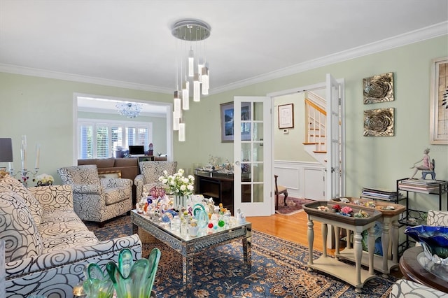 living room with a chandelier, ornamental molding, and wood finished floors