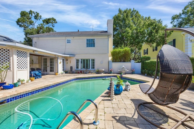 view of pool featuring french doors, a patio area, fence, and a fenced in pool