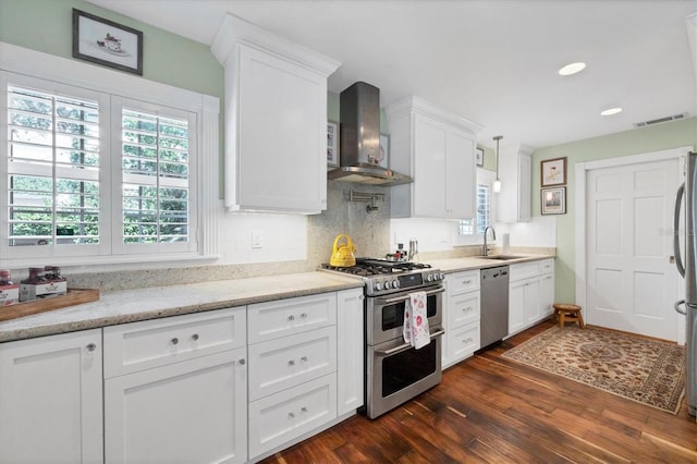 kitchen featuring dark wood-style floors, stainless steel appliances, white cabinets, a sink, and ventilation hood