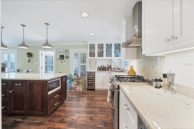 kitchen with range with two ovens, wine cooler, white cabinetry, wall chimney range hood, and built in microwave