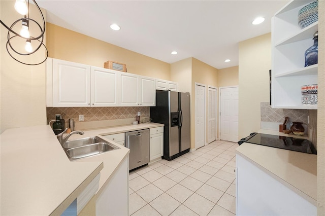 kitchen with stainless steel appliances, white cabinetry, sink, decorative light fixtures, and decorative backsplash