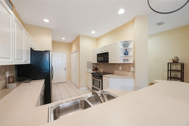 kitchen with white cabinetry, sink, black appliances, light tile patterned floors, and backsplash